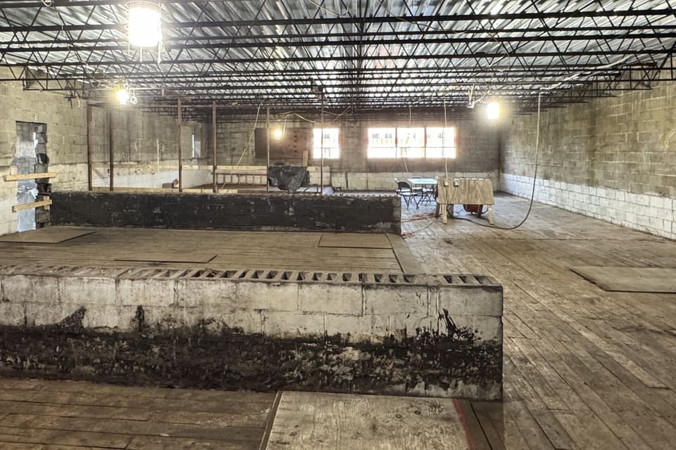 The future second-floor conference room mid-demolition, with exposed concrete-block walls and construction debris throughout.